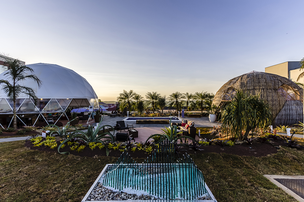 <span>Praça de Eventos Casa Cor - Márcio Carmona, Cíntia Teixeira e Henrique Veiga Júnior. A praça conta com dois domos geodésicos, um deles revestido em bambu, para acomodar eventos que ocorrerão durante a mostra. A piscina de pastilhas é automatizada e pode ser comandada pelo celular.</span>