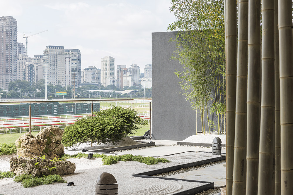 Alalou Paisagismo - Espaço Zen. Felipe e Maria Lúcia Alalou propõem uma nova forma de contemplar a vista do Jockey, a partir de um jardim japonês. Pedras rústicas remetem a montanhas e a areia, ao percurso da vida. O protagonista é o bambu, em toras que formam uma cortina.