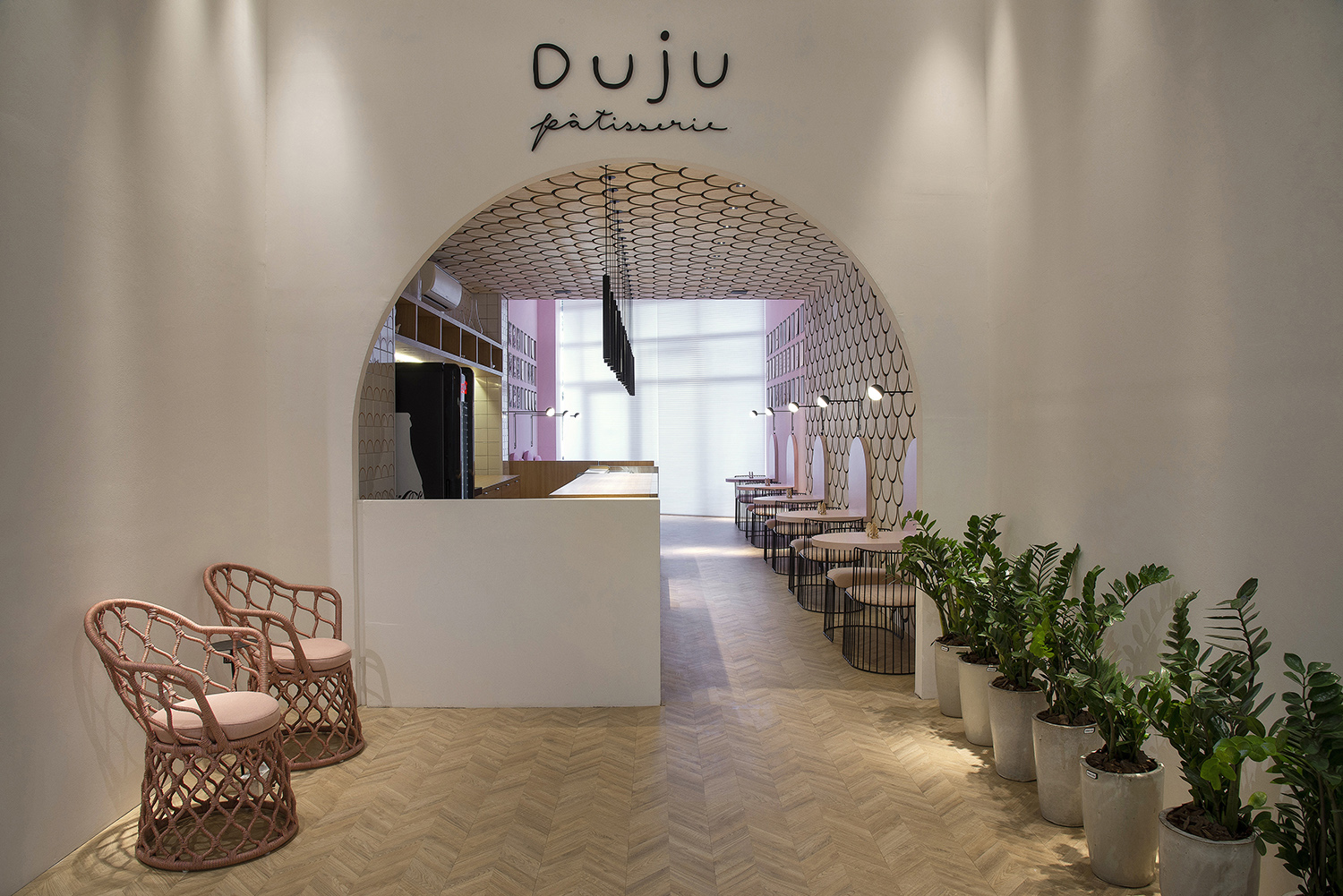 Duju Pâtisserie – Eduardo Medeiros. Neste ambiente de tons pastéis, vários elementos arquitetônicos remetem ao U da logomarca. Ele é citado no acesso em formato de arco, nas mesinhas laterais e até no revestimento em madeira que percorre paredes e o teto. Em primeiro plano, poltronas Painho, da Tidelli.