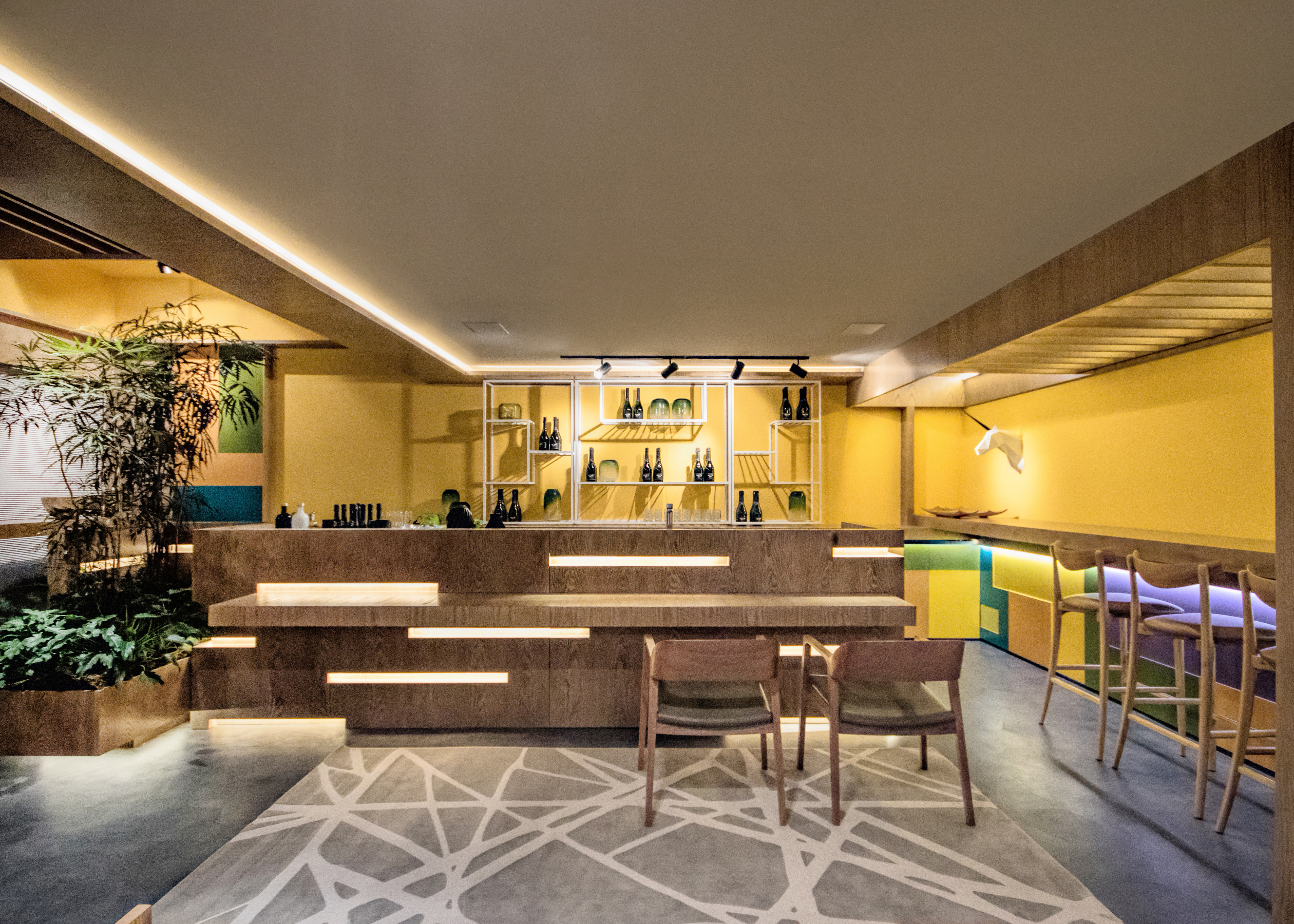 CASACOR Paraná 2019. Upscale Bar - Alessandro Cavalcanti e Ricardo Makhoul. Este bar solar tem inspiração no sunset californian, unindo música e arquitetura em 62 m². Layout flexível e tons alegres de laranja, verde e azul deixam o espaço convidativo. No piso, o cinza neutraliza a composição. Destaque para o bar, onde se alternam madeira laminada, laca colorida, couro, aço carbono e plantas.