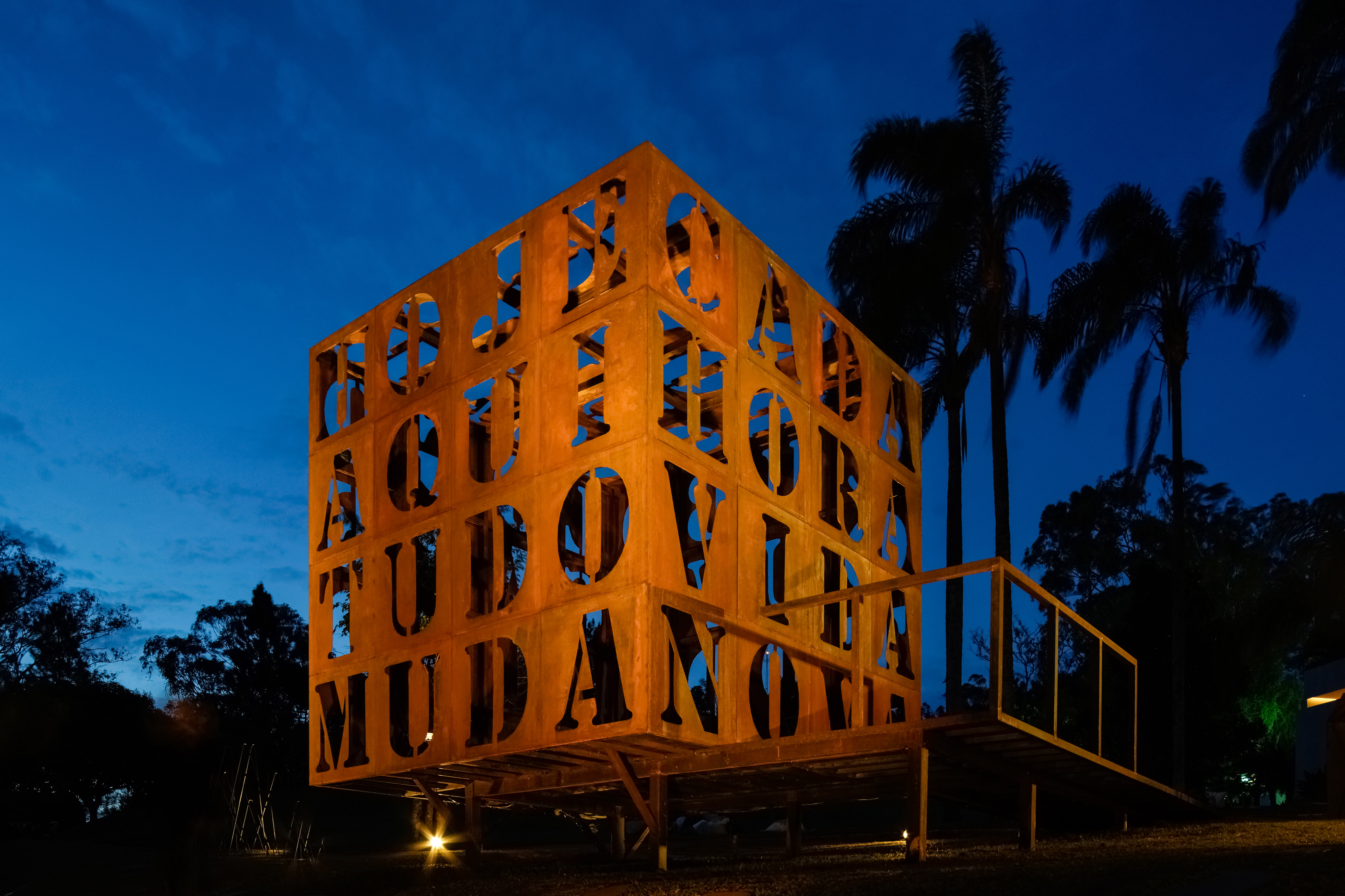 Bel Diniz e João Diniz - Cuboesia & Jardim de Aço. Cuboesia é nome para uma instalação híbrida que une arquitetura, design, escultura, paisagismo e poesia. É estimulada a interação com o texto poético, através da possibilidade de adentrar os versos inscritos nas faces do cubo de metal. Este é circundado pelo Jardim de Aço – composição escultórica que sugere que o aço também é parte da natureza.