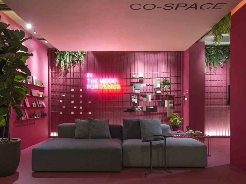 O Co-Space para Arquitetos e Designers, de Barbara Ramos e Maria Eduarda Brandão para Santa Catarina | Florianópolis, entende o ambiente de trabalho como também propício para momentos de descompressão. Instagramável, a caixa que envolve todo o espaço e cria unidade visual foi tingida de pink. O perfeito contrapondo é a cor verde, inserida por meio dos ficus, samambaias e jibóias que dão vida ao lugar. O sofá modular torna o ambiente versátil, na mesma pegada das prateleiras e da tela metálica que deixam as paredes mais funcionais.