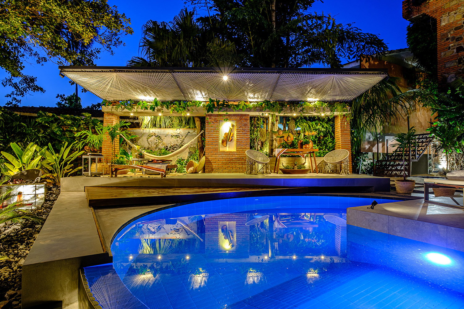 Reflejos Chiquitanos - Piscina - Oscar Anglarill. A piscina torna-se o cenário perfeito para misturar elementos ecológicos, inovadores e tecnológicos. O tijolo aparente, o concreto armado, o porcelanato e a madeira são materiais que se misturam de forma estética, dando continuidade ao estilo arquitetônico da própria casa. Neste projeto, o sistema de deck automatizado ajuda na  otimização do espaço e, graças a sua tecnologia, permite o fechamento parcial ou total da piscina.