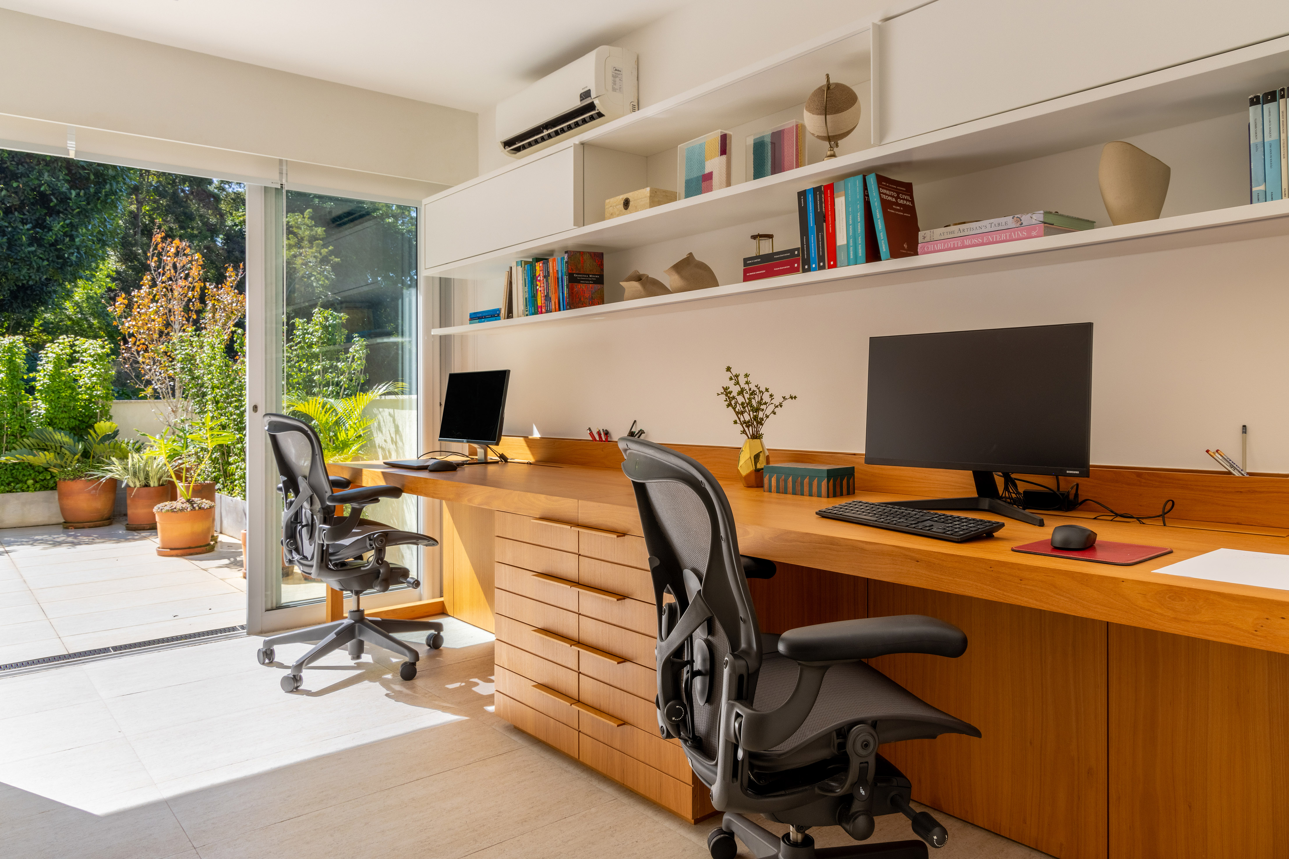 Casa no Jardim Botânico ganha frescor com áreas externas repletas de verde. Projeto de Manuela Santos. Na foto, home office com terraço com plantas.